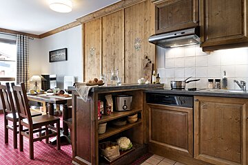 A kitchen with wooden cabinets and appliances including a toaster oven