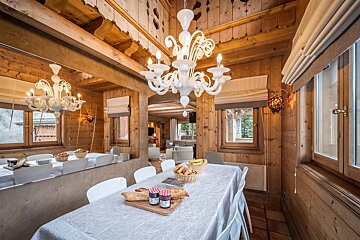 A dining room with a table and chairs and a chandelier