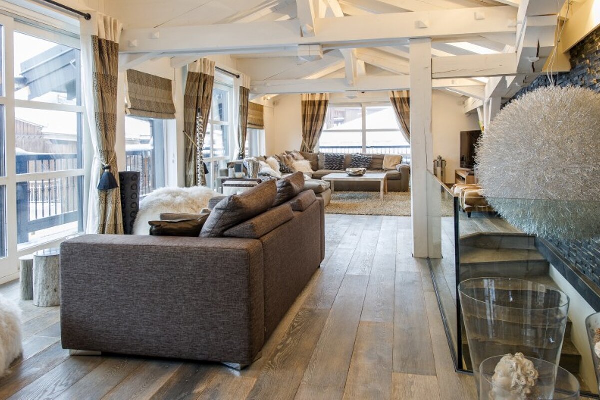 A living room with a couch and stairs leading up to the second floor