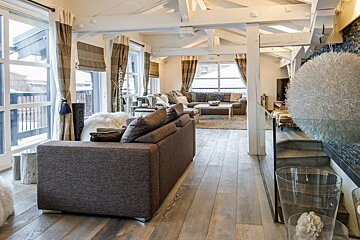 A living room with a couch and stairs leading up to the second floor
