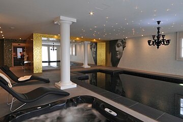 A swimming pool with a chandelier hanging from the ceiling