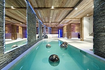 A large indoor swimming pool surrounded by stone walls