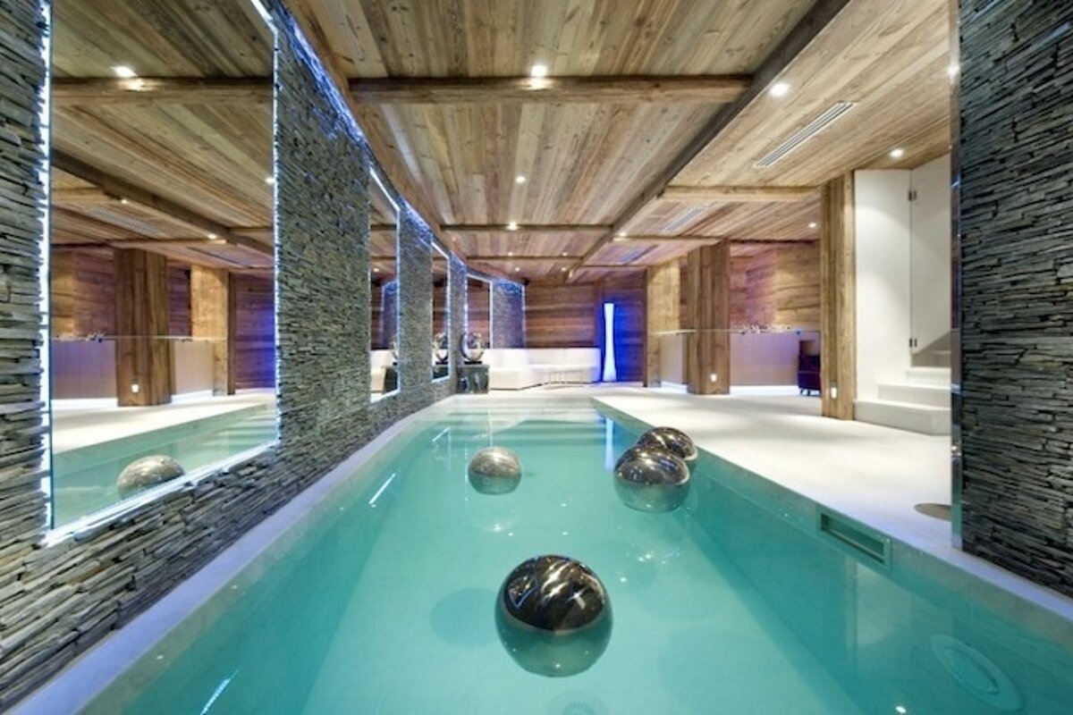 A large indoor swimming pool surrounded by stone walls