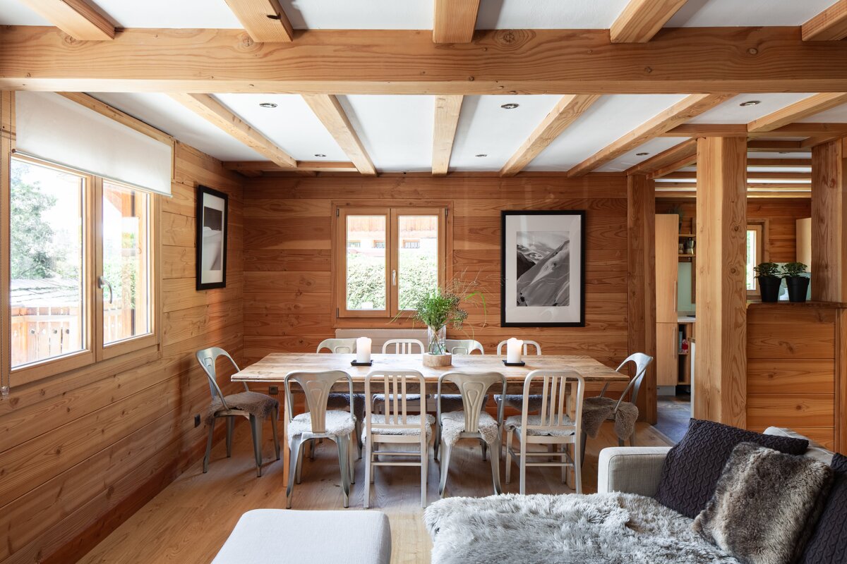 A wooden dining room with a table and chairs
