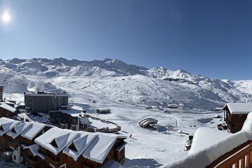 A snowy mountain landscape with a hotel in the foreground