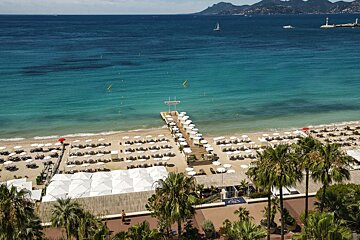An aerial view of a beach with umbrellas and chairs