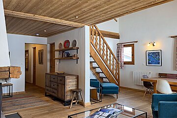 A living room with a staircase leading up to the second floor