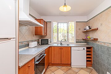 A kitchen with wooden cabinets and a white dishwasher