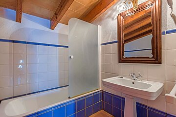 A bathroom with blue and white tiles and a sink