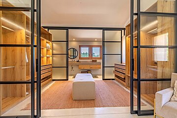 A walk in closet with sliding glass doors leading to a bathroom