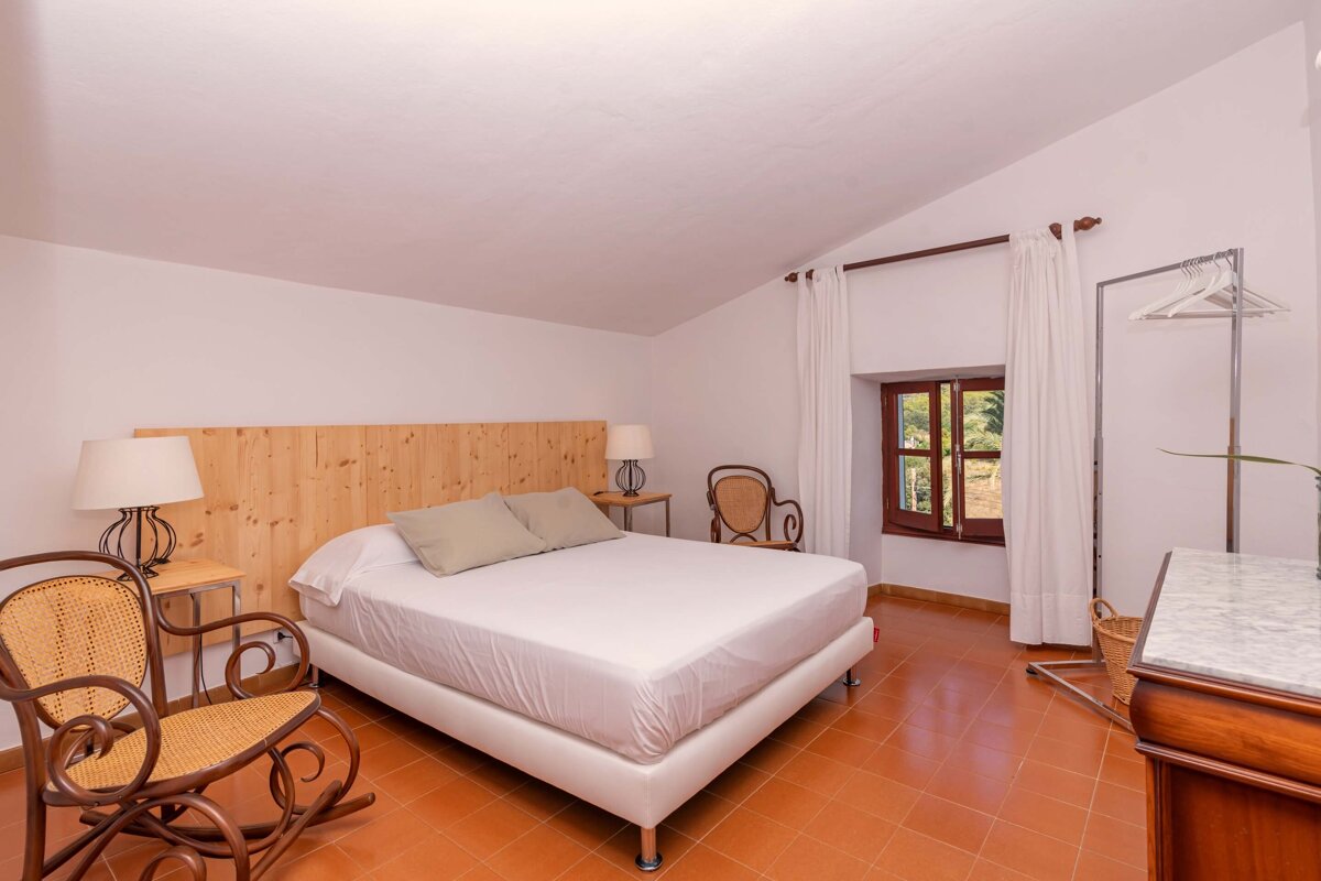 A bedroom with a large bed and two rocking chairs