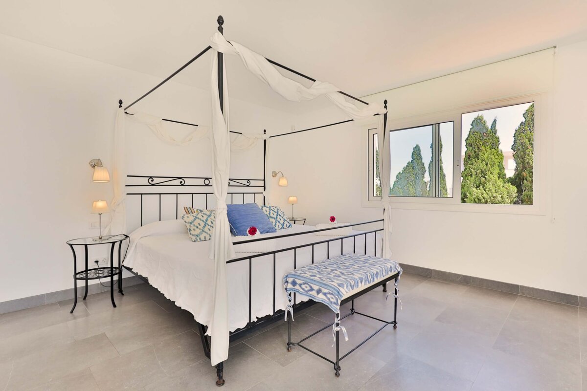 A bedroom with a canopy bed and a window