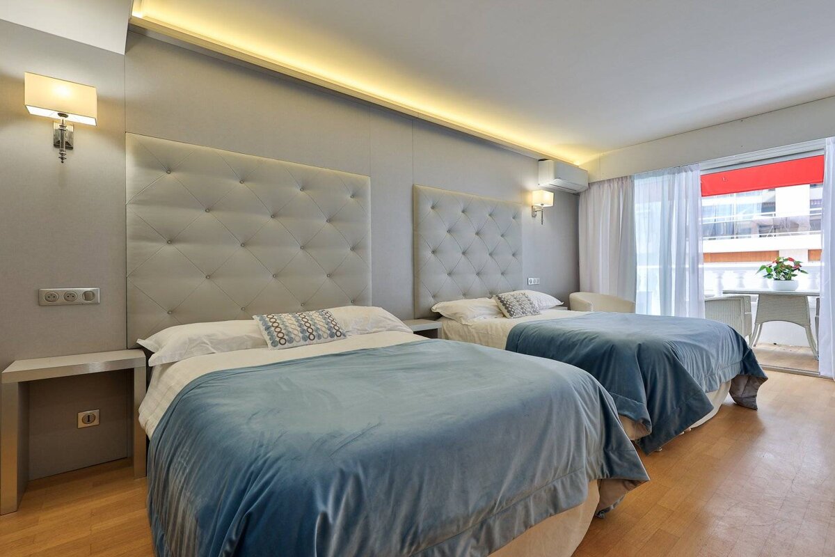 A hotel room with two beds and a balcony