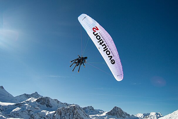 A person is flying through the air with a parachute that says evolution 2