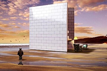 A child stands in front of a brick wall on the beach
