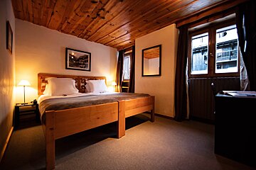 A hotel room with two beds and two mirrors