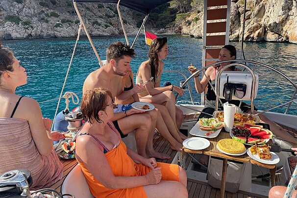 A group of people sitting on a boat eating food