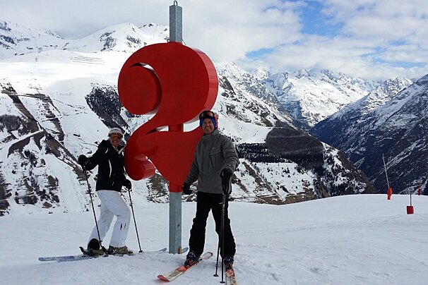 2 people stood next to a large red 2 on the pistes