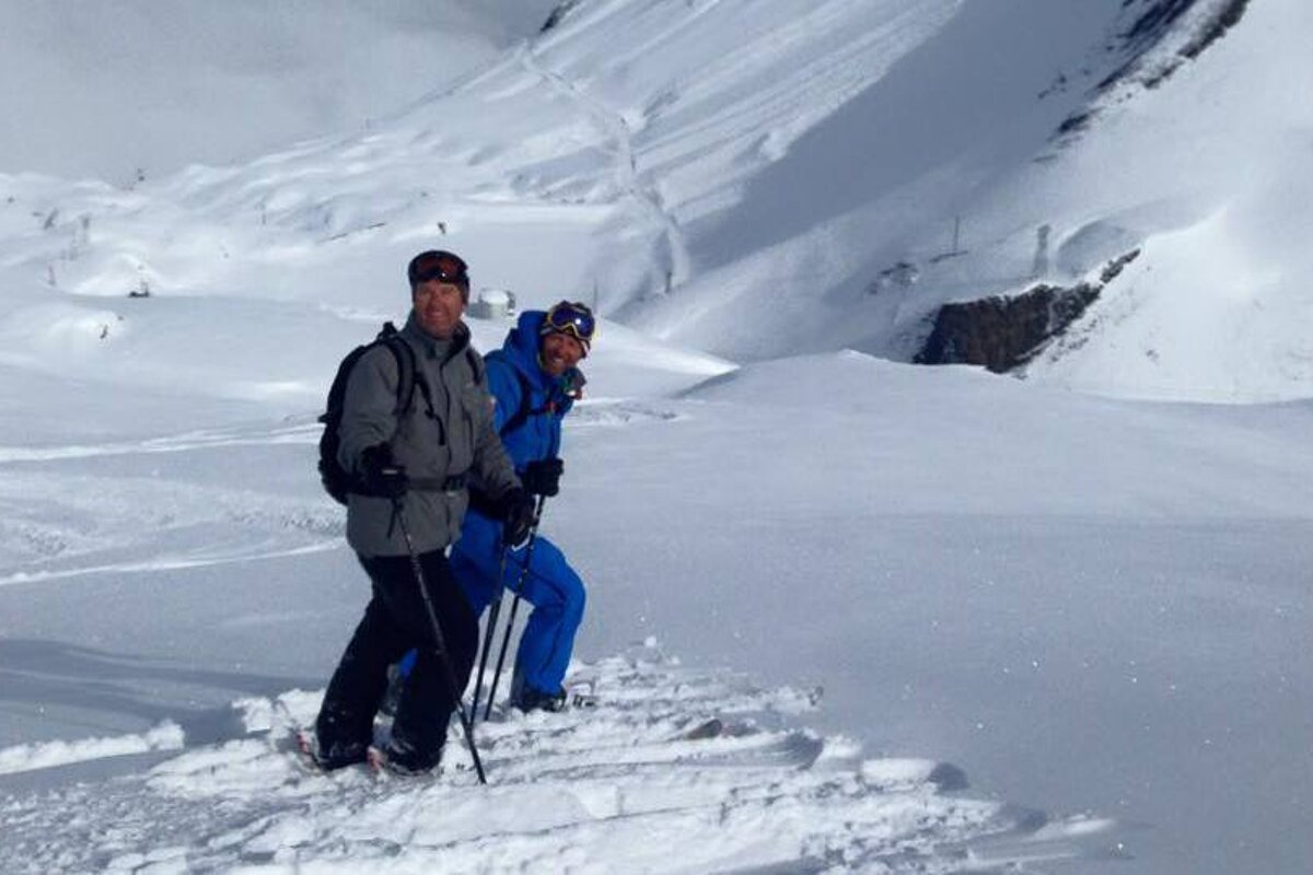 a ski instructor in a blue outfit with a client