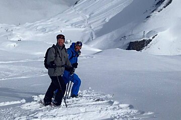 a ski instructor in a blue outfit with a client