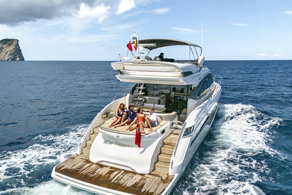 A group of people are sitting on the back of a yacht named mrs. paradise