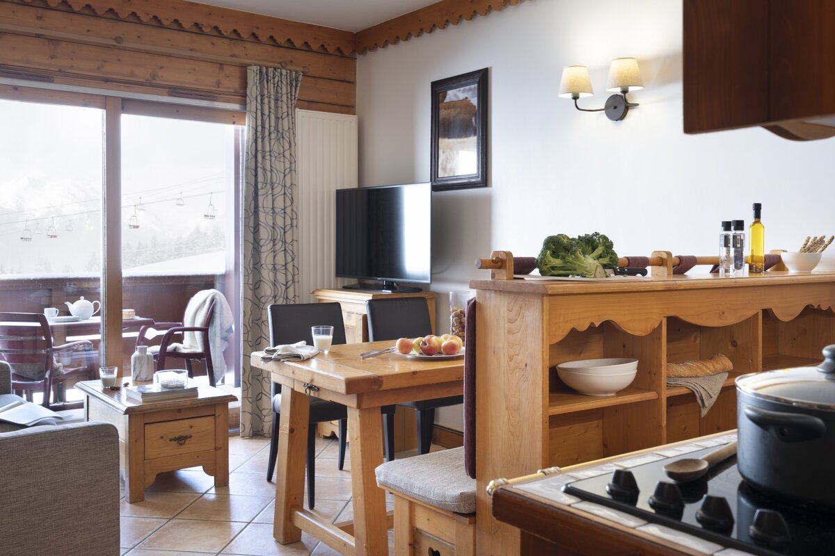 A living room with a table and chairs and a television