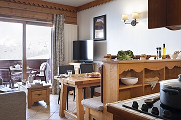 A living room with a table and chairs and a television