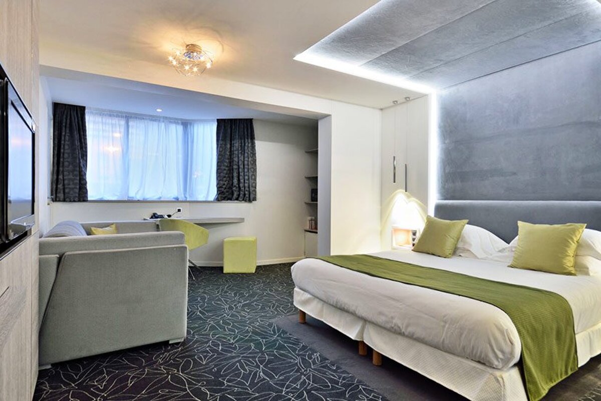 A hotel room with a large bed and a couch