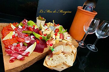 A bottle of le mas de mougins wine sits in a wine cooler