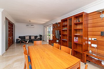 A living room with a wooden table and chairs