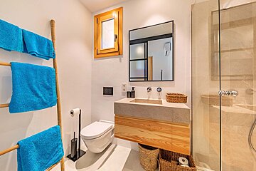 A bathroom with blue towels and a toilet