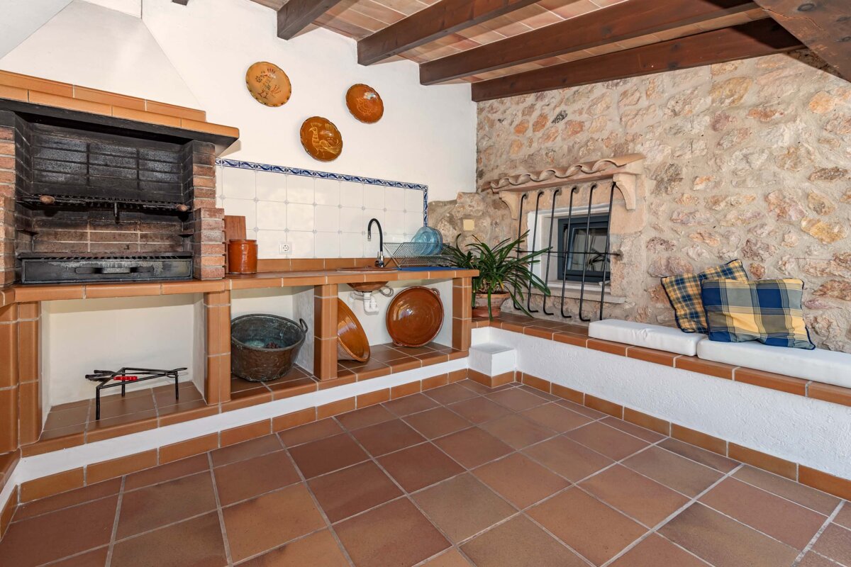 A kitchen with a brick fireplace and plates on the wall