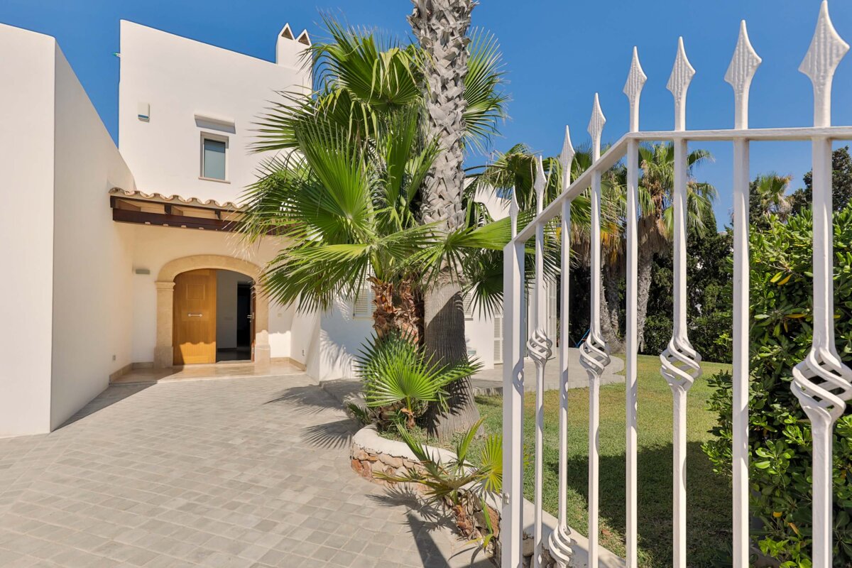 A white house with a palm tree in front of it