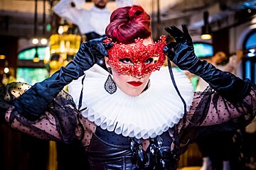 A woman wearing a red mask and black gloves