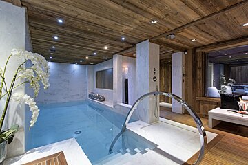 A large indoor swimming pool with a wooden ceiling
