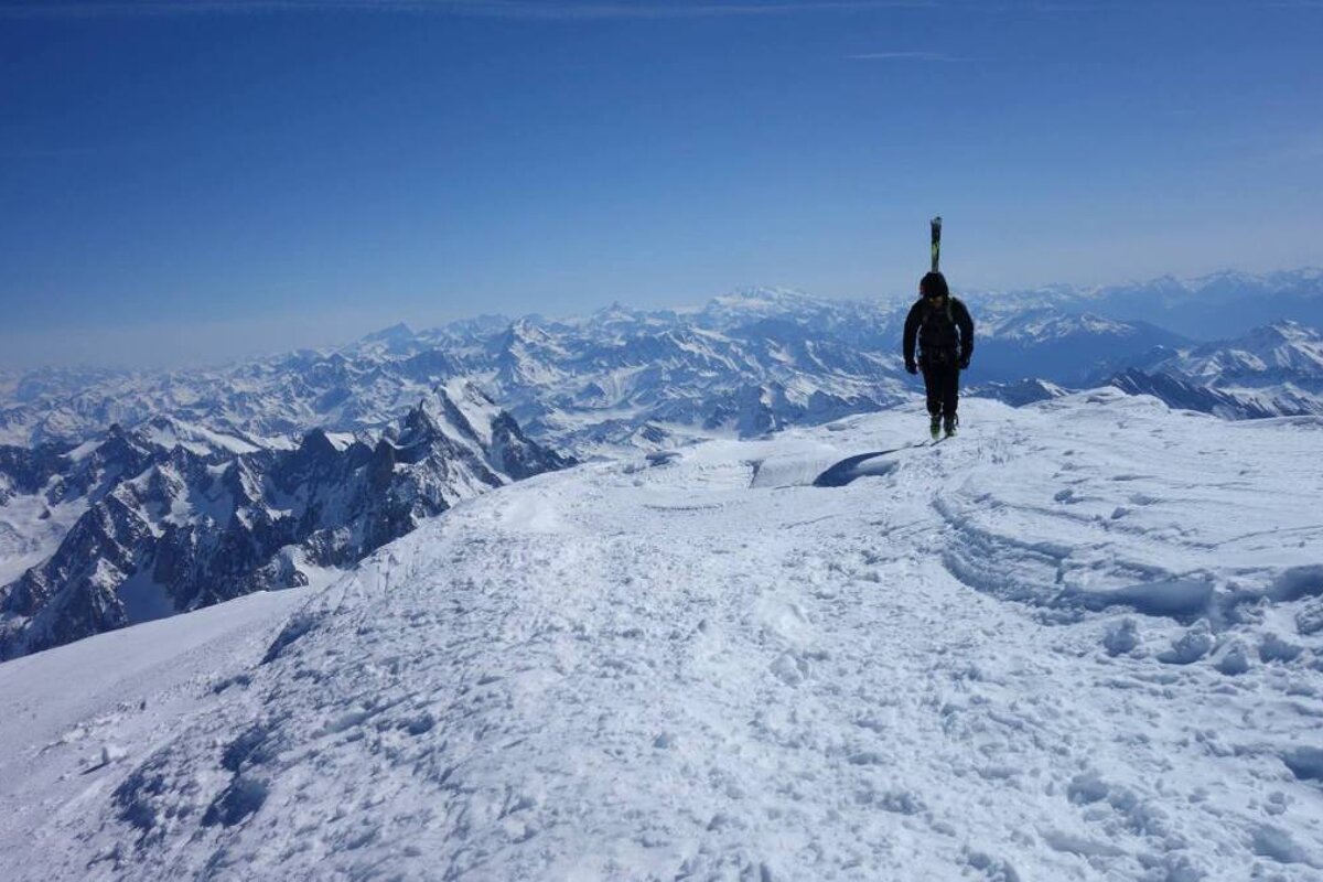 A person standing on top of a snow covered mountain