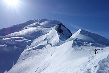 A person walking up a snow covered mountain
