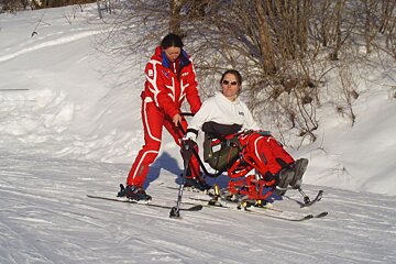 A disabled skier tries assisted skiing in a sitski