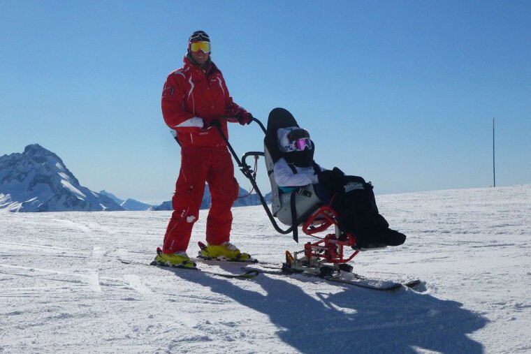 A disabled skier tries assisted skiing in a sitski