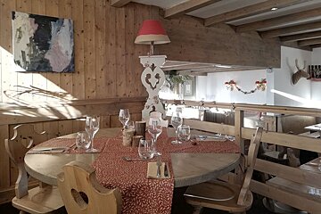 A table with a red table runner and glasses on it