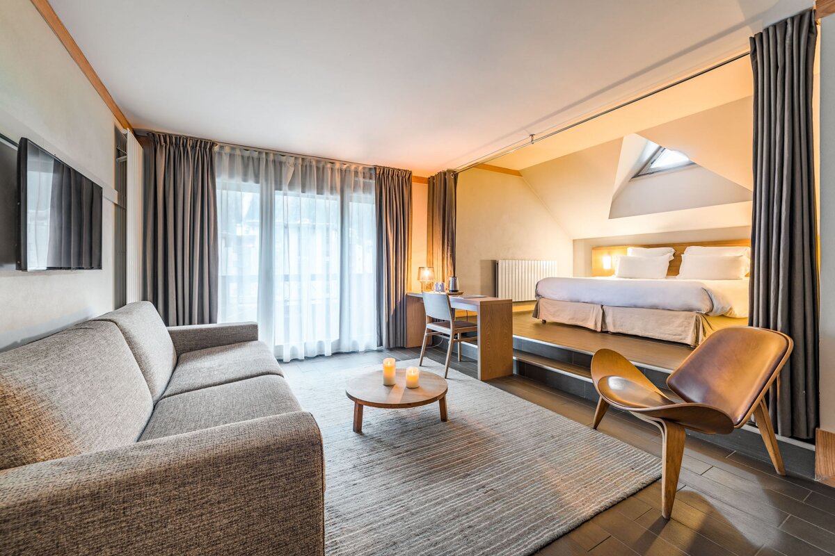 A hotel room with a couch and a chair