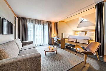 A hotel room with a couch and a chair