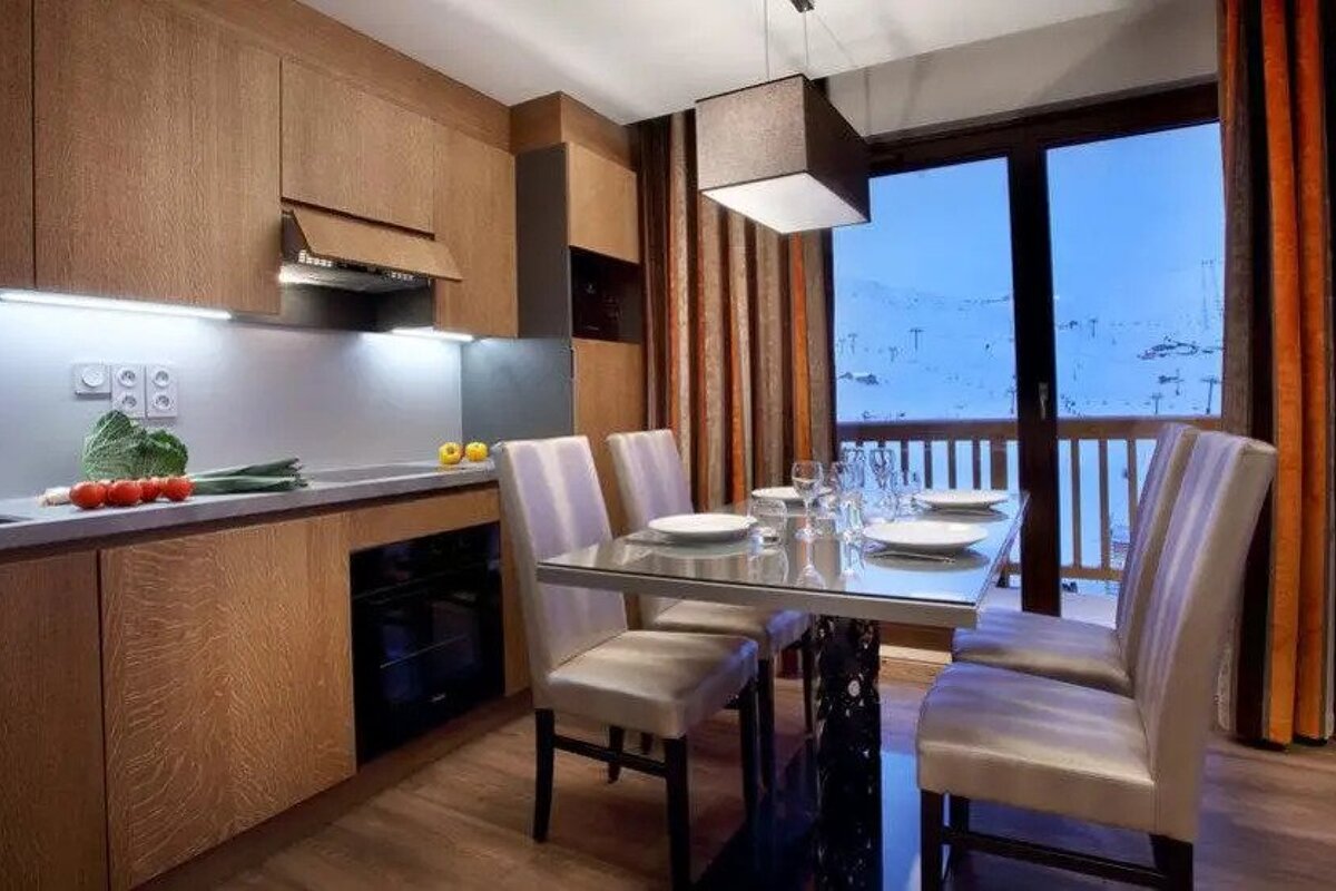 A kitchen with a dining table and chairs and a sliding glass door