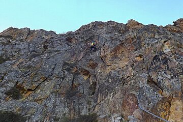 a man climbing up a rock face in val thorens