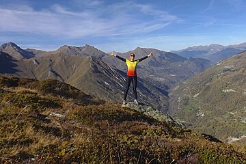 a woman celebrating getting to the top of a mountain