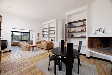 A living room with a table and chairs and a fireplace