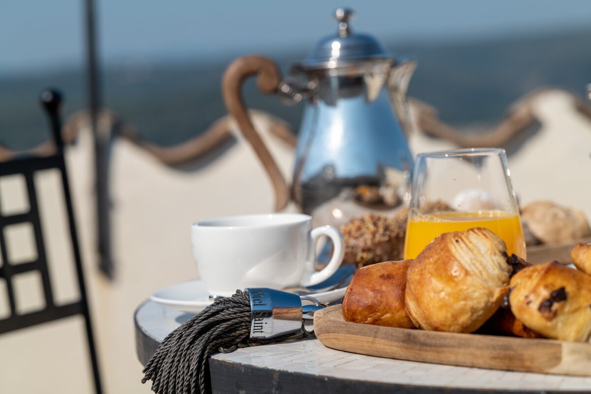 A table with a cup of coffee croissants and orange juice