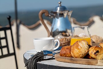 A table with a cup of coffee croissants and orange juice