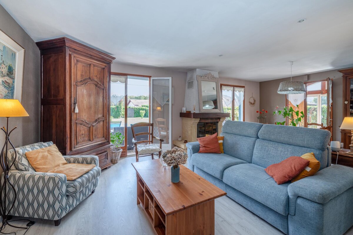 A living room with a blue couch and a wooden cabinet