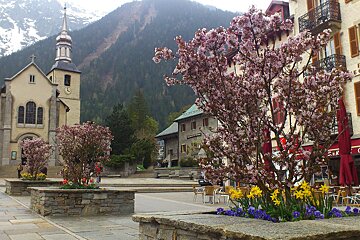 An image of a church and mountains and flower beds in Chamonix Mont Blanc